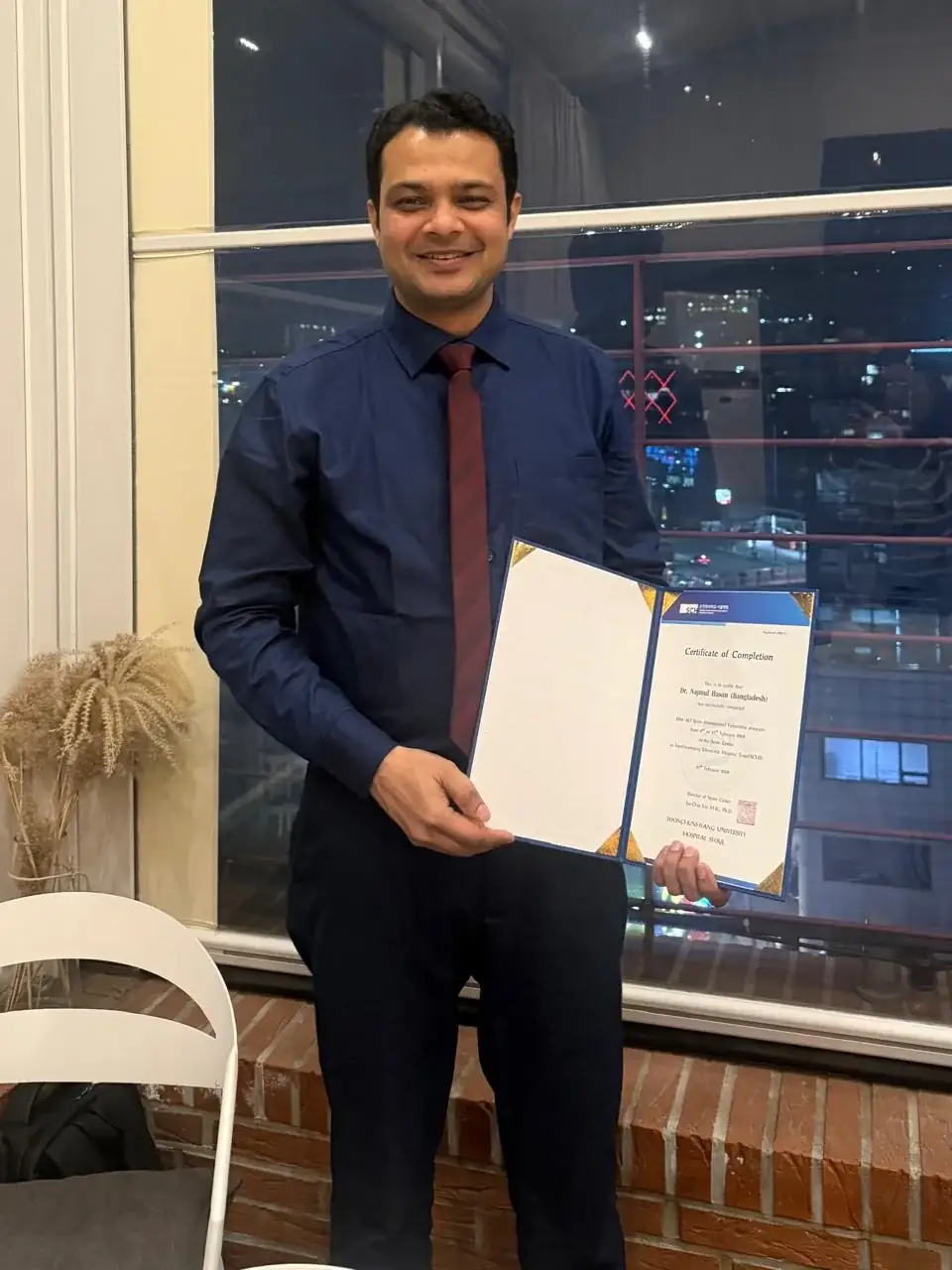 Dr Najmul Hasan holding a certificate of completion
